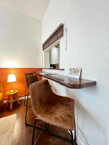 Cette chambre comprend un bureau, 2 chaises et un miroir. dans l'établissement Le Solférino, Rennes centre gare, à Rennes