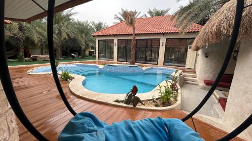 a view of a swimming pool in a house at منتجع اكواخ النخيل in Al Muţayrifī