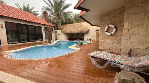 una piscina en medio de una casa en منتجع اكواخ النخيل en Al Muţayrifī