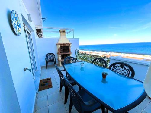 カルボネラスにあるÁtico con vistas al marの海が見えるバルコニーに置かれた青いテーブルと椅子