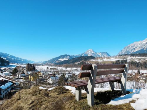 a wooden bench sitting on top of a hill with mountains at Holiday Home LuxuSölk-5 by Interhome in Stein an der Enns