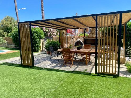 a gazebo with a table and chairs in a yard at NikLuDin suites & studios in Laganas
