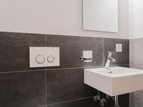 a bathroom with a white sink and a mirror at Apartment Rosablanche E003A by Interhome in Siviez