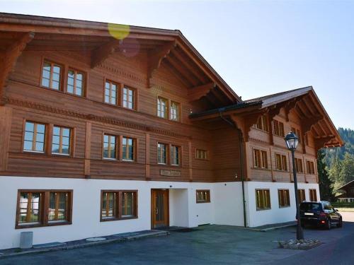 een groot houten gebouw met een auto voor de deur bij Apartment Jacqueline 1 by Interhome in Gstaad