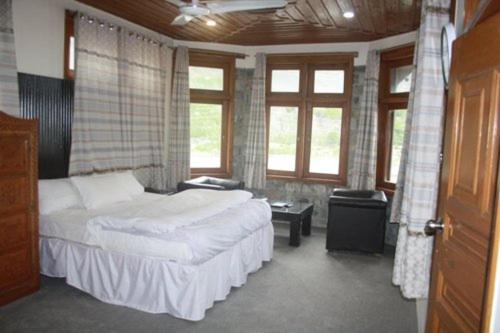 a bedroom with a bed and a room with windows at Hideway Cottage in Chīkīdam