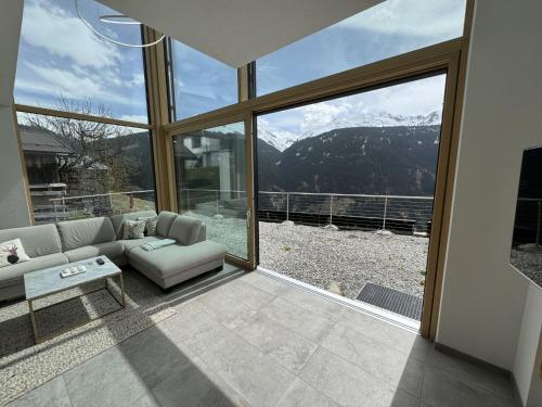 a living room with a couch and a large window at Holiday Home Skyline Retreat by Interhome in See
