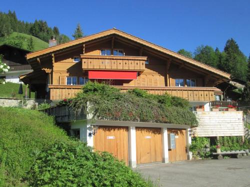 ein Haus mit einem grünen Dach mit einem Gebäude in der Unterkunft Apartment Isabelle by Interhome in Lenk im Simmental