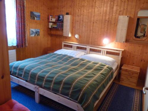 オヴロナにあるApartment Beau Site 7 by Interhomeの木製の部屋にベッド1台が備わるベッドルーム1室があります。