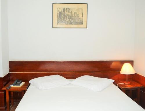 a bedroom with a bed with a wooden head board at Hotel Americas in Fortaleza