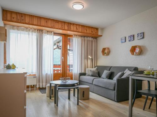 a living room with a couch and a table at Apartment Eaux-Vives 213 by Interhome in Ovronnaz