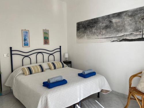 a bedroom with a bed with two blue pillows on it at Rosa Dei Venti Marettimo in Marettimo