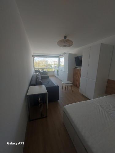 um quarto com uma cama, um sofá e uma mesa em Studio vue port à 50m plage em Carnon-Plage