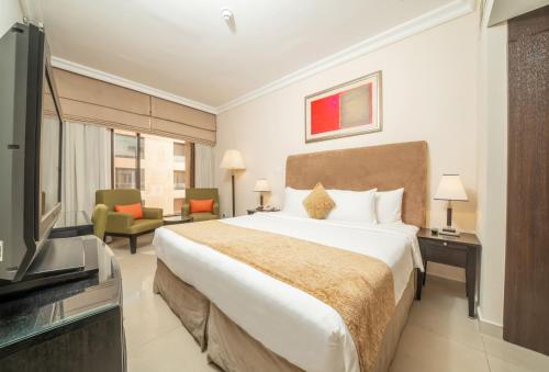 a hotel room with a bed and a television at Mercure Dubai Barsha Heights Hotel Suites And Apartments in Dubai