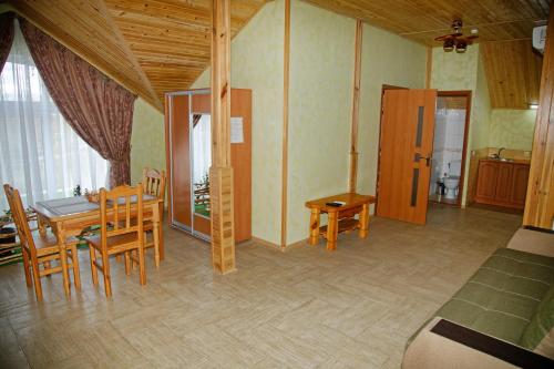 a dining room with a table and chairs in a room at Mini-hotel Yandrusi in Kamianets-Podilskyi