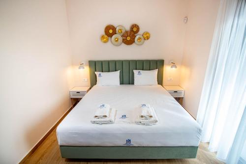 a bedroom with a bed with two towels on it at Perdika Ionion Villas in Perdika