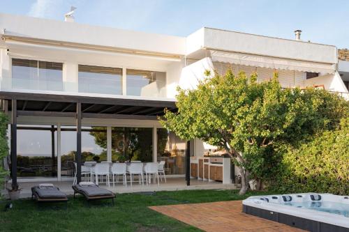 a white house with a patio and a swimming pool at Casa Amalia in Aghia Marina