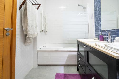 bagno con vasca, lavandino e specchio di Porto Sea Front Apartment a Lavra