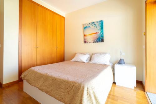 a bedroom with a bed with a wooden cabinet at Porto Sea Front Apartment in Lavra