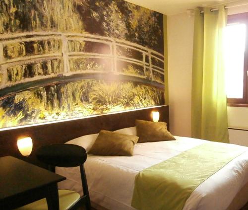 een slaapkamer met een bed met een schilderij aan de muur bij Le Merle Blanc in Digoin
