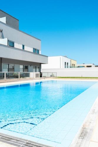 a swimming pool in front of a building at Porto Sea Front Apartment in Lavra