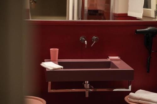 a sink in a bathroom with a red wall at Sant'Eufemia 30 in Modena