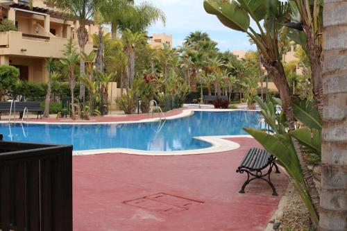 a swimming pool with a bench next to a building at Espectacular casa Playas de Vera in Playas de Vera