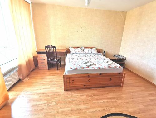 1 dormitorio con 1 cama y 1 silla en Purvciems, Ieriķu apartment, en Riga