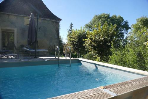 - une piscine à côté d'une maison dans l'établissement Cozy town centre cottage, à Beaumont-du-Périgord