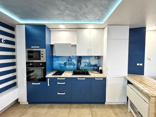 a blue and white kitchen with white cabinets at The Captain in Varna City