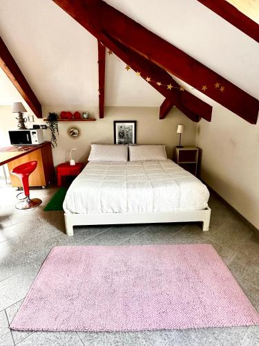 a bedroom with a white bed and pink rugs at Loft centro storico Tommaso in Turin