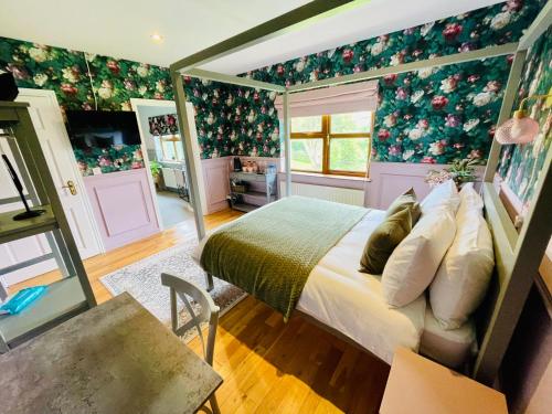 a bedroom with a bed and floral wallpaper at Carnbore House BnB in Bushmills