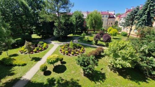 einen Blick über einen Garten mit Blumen und Bäumen in der Unterkunft Apartament na Błoniach in Sanok