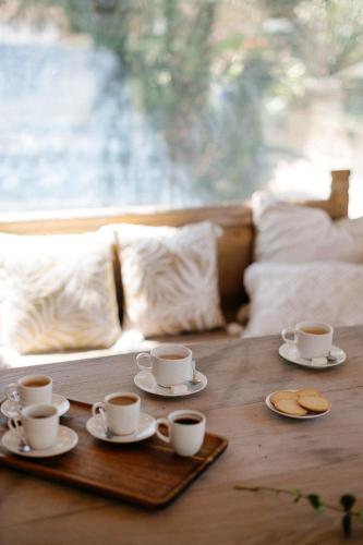 two cups and saucers on a wooden table at Hotel Finca El Peregrino in Puente la Reina