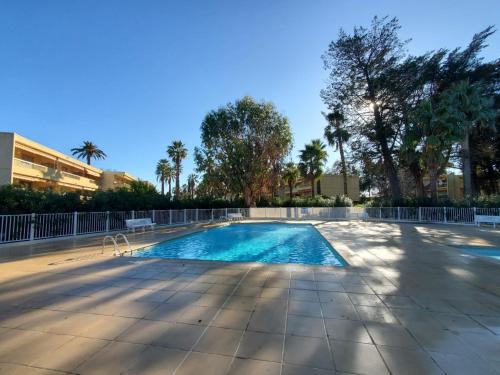- une piscine bordée d'arbres et de palmiers dans l'établissement L'Eden - Spacieux 3P Bord de Mer - Juans les Pins, à Antibes