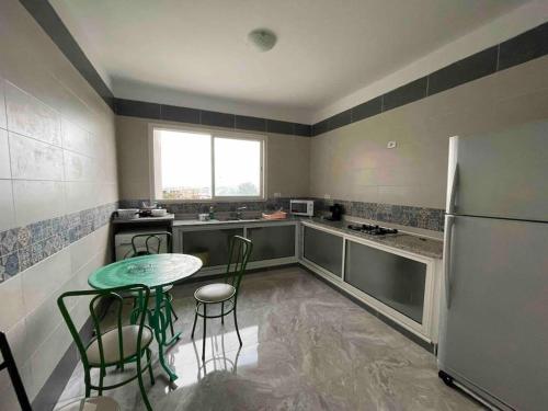 a kitchen with a table and a refrigerator at Spacious two room apartment with a super view in Bizerte