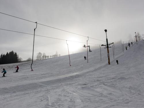 a group of people skiing down a snow covered ski slope at Holiday Home Huty by Interhome in Jimramov