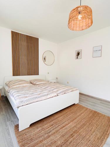 a white bedroom with a bed and a rug at Stilvolles Apartment am ICE Bahnhof in Kassel