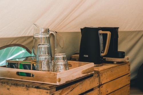 a wooden box with glasses and a blender on a table at Glamping op boutique camping Whanau in Rutten
