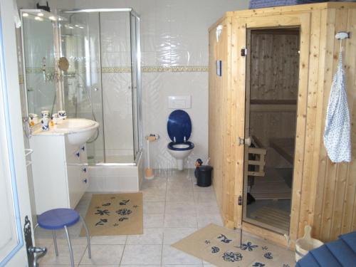 a bathroom with a shower and a toilet and a sink at Kleines Ferienhaus am Meer in Guissény