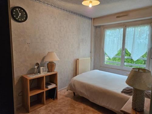 - une chambre avec un lit, une fenêtre et une horloge dans l'établissement Grand T4 avec parking, à Montbéliard