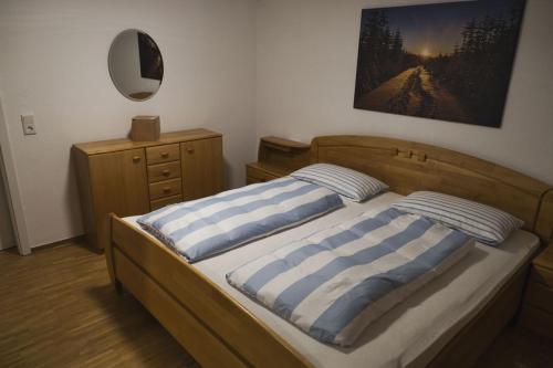een slaapkamer met een bed met 2 gestreepte kussens bij Paradiesken am Berg in Schmallenberg