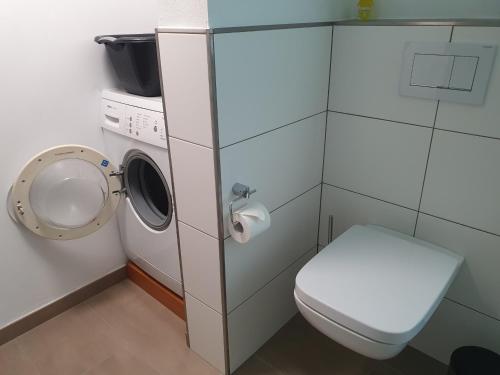 een badkamer met een wasmachine en een toilet bij Paradiesken am Berg in Schmallenberg