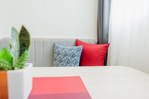 a bed with colorful pillows and a potted plant at Hotel Midtown Ratsada in Phuket Town