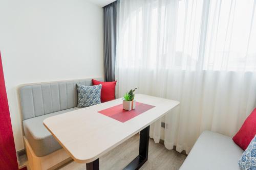 a room with a white table and a couch and a table at Hotel Midtown Ratsada in Phuket Town