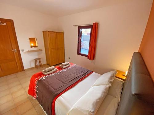 a bedroom with a bed with a couch and a window at CASA JAMACO, Corralejo in Corralejo