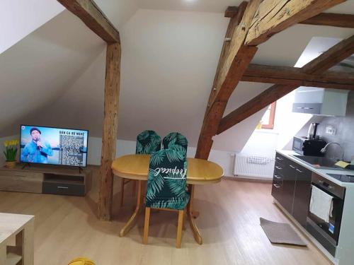 a kitchen with a table and chairs and a tv at Apartment U Černého Orla in Karlovy Vary
