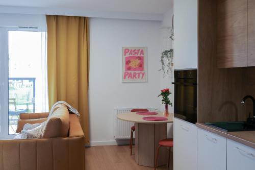 uma cozinha com um sofá e uma mesa num quarto em Glow Apartments, Apartamenty Nowa Letnica em Gdansk