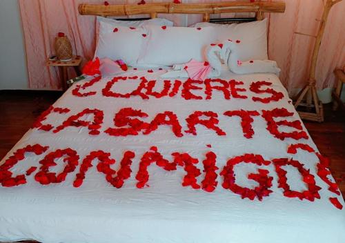 a bed with red flowers on top of it at Laguna Rosa Glamping in Coveñas
