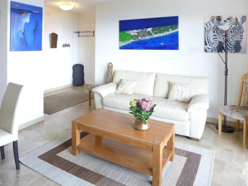 a living room with a white couch and a coffee table at Apartment Clairière des Barzettes B16 by Interhome in Crans-Montana
