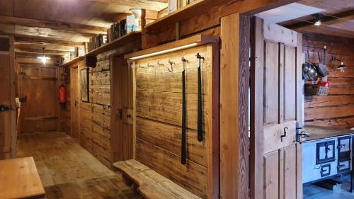 a room with a wooden wall with a shower in it at Almhütte Oberschaller bei Alfenalm - Ferienwohnungen am Berg in Innervillgraten